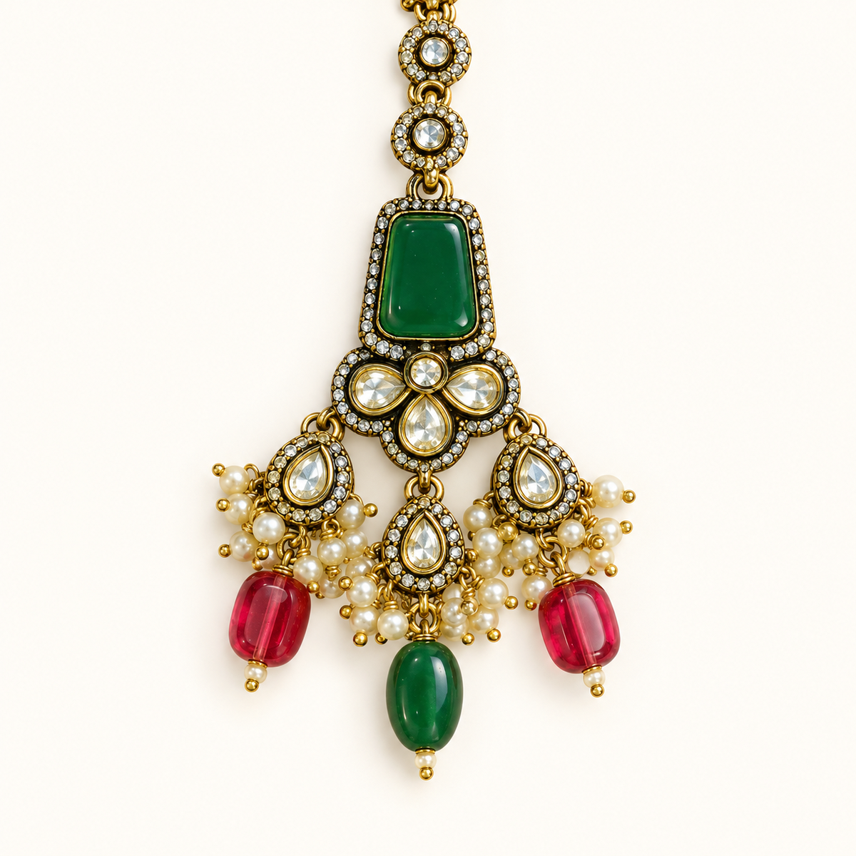 Groen-rode sieradenset met kralenhangers — close-up van de maang tikka