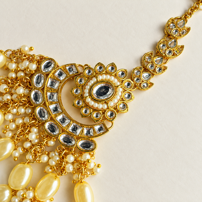 Sieradenset met drie rijen kralenfranjes en jhumka-oorbellen — close-up van de maang tikka